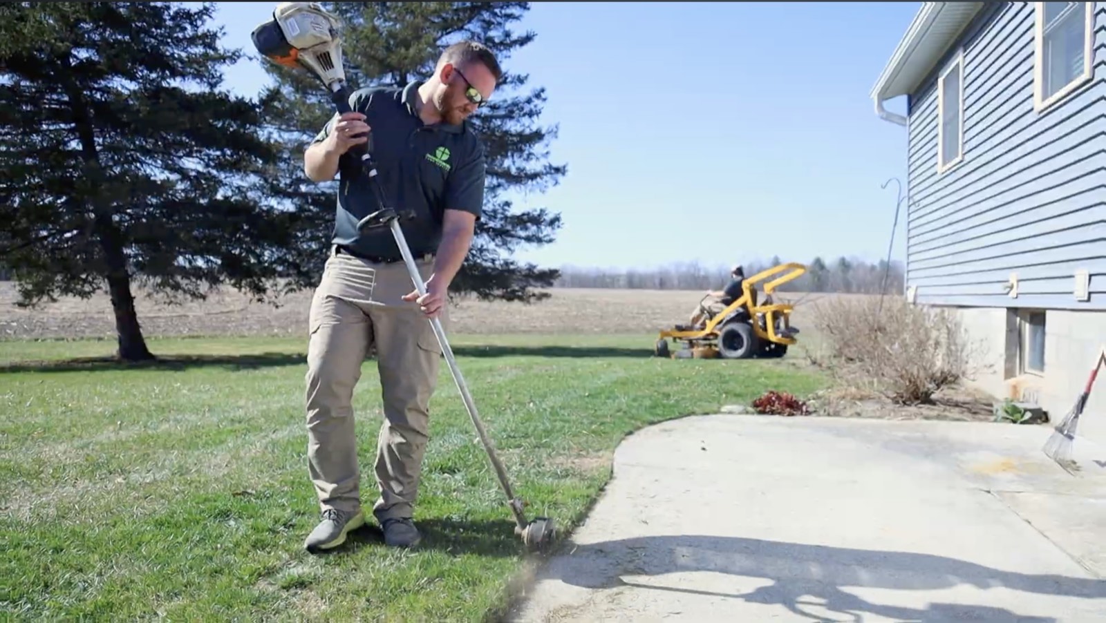 CrossCountry crew string-trimming edges on a West Michigan property