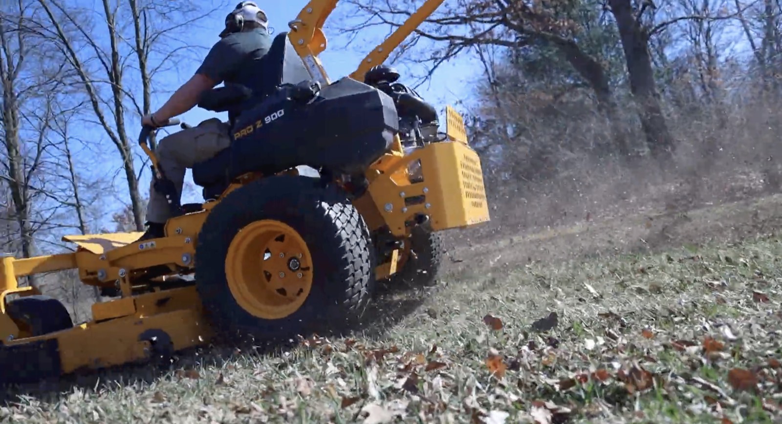 Commercial zero-turn mowing and mulching fall leaves in West Michigan